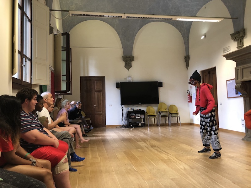 Commedia dell'Arte student performing for the class, wearing a traditional Commedia dell'Arte mask.